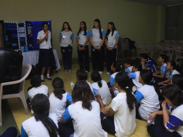 Un grupo de estudiantes de octavo grado de la María Mazzarello realizando una presentación de su proyecto a otros alumnos de la institución.