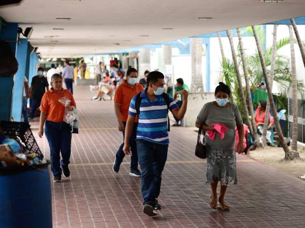 Familiares de pacientes y personal del hospital caminan por uno de los pasillos del Mario Rivas.