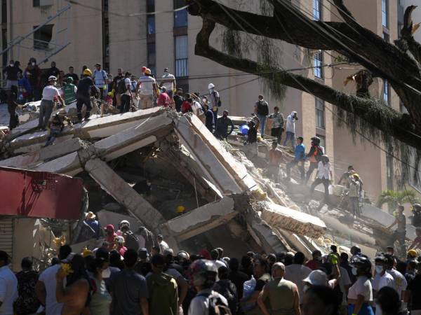 Personas trabajan en labores de rescate en una edificación colapsada por el terremoto de magnitud 7.4 que sacudió al país este lunes, en Cali.