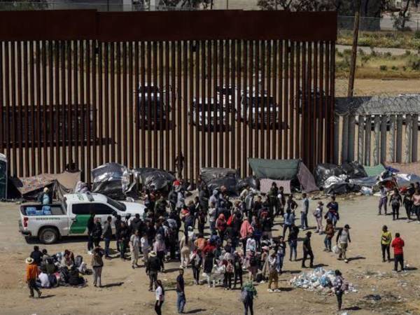 Migrantes en un campamento junto al muro fronterizo, en Tijuana, Baja California (México).