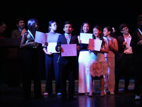 Los alumnos de la academia posan con su diploma por culminar con éxito su período anual de educación musical.