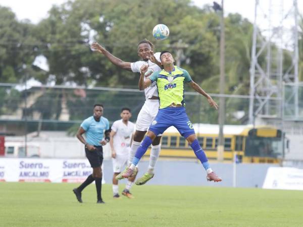 Georgie Welcome y Juan Ángel Delgado saltan por la disputa del balón.