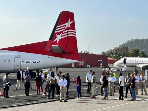 Migrantes esperan para subir a un avión para un vuelo de deportación.