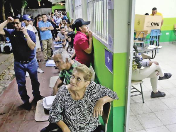 Cientos de personas hacían fila anoche a las puertas del centro de votación de la escuela John F. Kennedy de la colonia Kennedy.