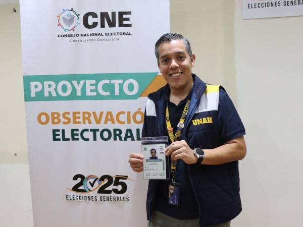 El rector de la Unah, Odir Fernández, muestra su credencial como observador del proceso electoral en Honduras.