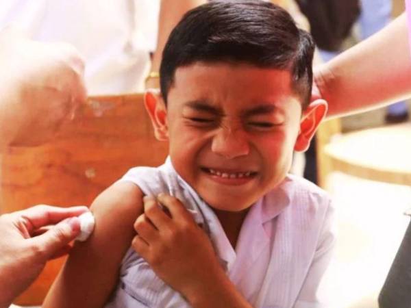 Personal de salud vacuna a niños y adolescentes contra el dengue en el centro básico Centenario José Trinidad Cabañas, en una jornada coordinada con la Regional de Salud Metropolitana de San Pedro Sula para fortalecer la prevención de la enfermedad.