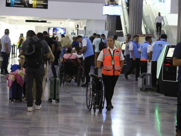Pasajeros y personal caminan por el aeropuerto Ramón Villeda Morales.