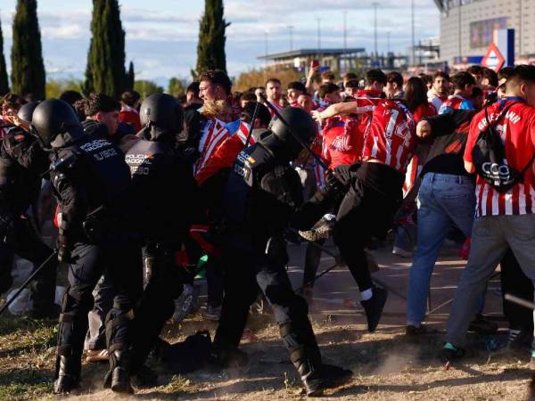 Miembros de la Policía Nacional cargan contra los aficionados del Atlético de Madrid en los alrededores del estadio Riyadh Air Metropolitano antes del partido.