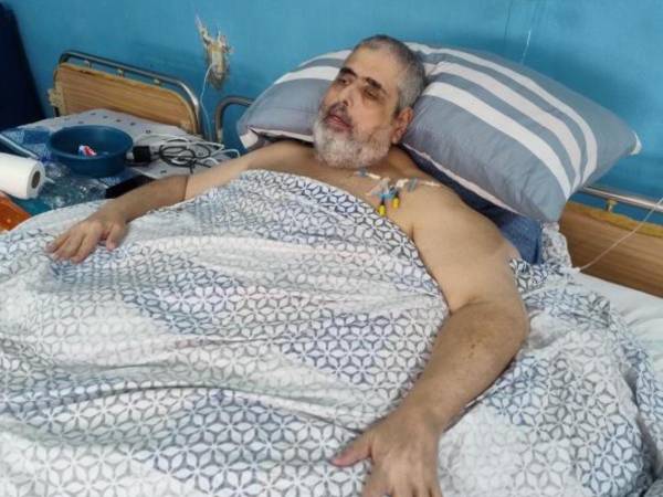 Nasser Hilsaca (de 56 años) permanece aislado en una sala del hospital Atlántida. Aunque aún presenta dificultad para respirar debido a su obesidad, su estado de salud ha mejorado.