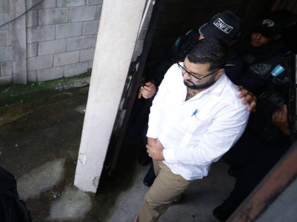 El exjuez Marco Vallecillo es escoltado por agentes de seguridad al salir de los tribunales.