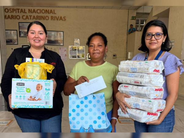 Las periodistas Jacqueline Molina y Eleana Enamorado entregan el donativo a Ana Cristina Burgos en representación de los lectores de Diario LA PRENSA.