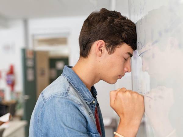 Un estudiante pasa a la pizarra a resolver una ecuación matemática.