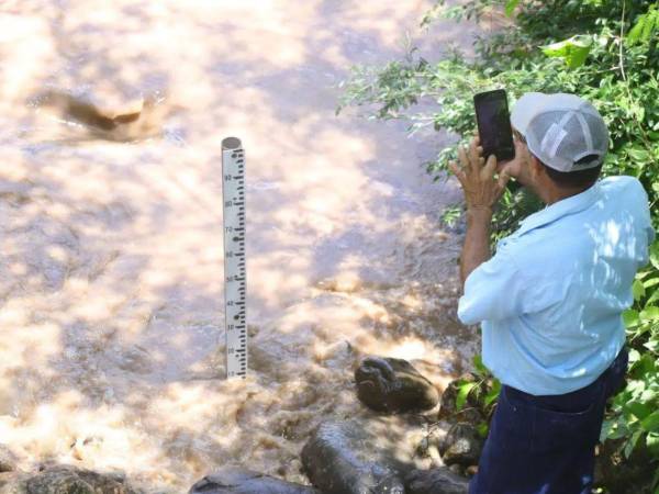 Cuando fallan las estaciones hidrometeorológicas, la medición de los ríos se hace de forma manual. El encargado del monitoreo del río Ulúa en la estación de Chinda, Santa Bárbara.
