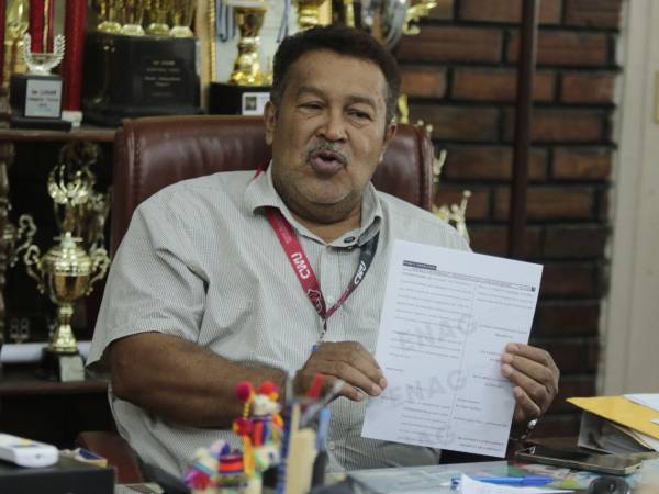 El director del instituto José Trinidad Reyes, Wilson Mejía, muestra el decreto mediante el cual el Congreso Nacional declaró a la institución de interés cultural para Honduras.