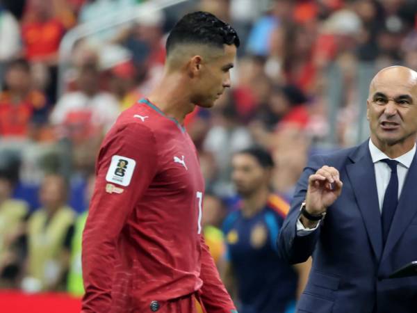 El portero Unai Simón de España se queda con el balón ante el acecho de Cristiano Ronaldo.
