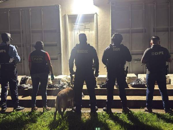 Agentes policiales ordenan los sacos de drogas decomidas en El Progreso, Yoro.