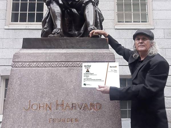 El doctor Alfredo Haces pone su mano derecha en el pie izquierdo de la estatua de John Harvard, creencia histórica y tradicional de buena suerte, en especial en lo académico y laboral.
