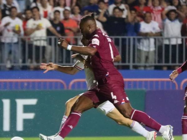 Kendall Waston del Saprissa en la disputa del balón con el delantero Imanol Enríquez de Olimpia.