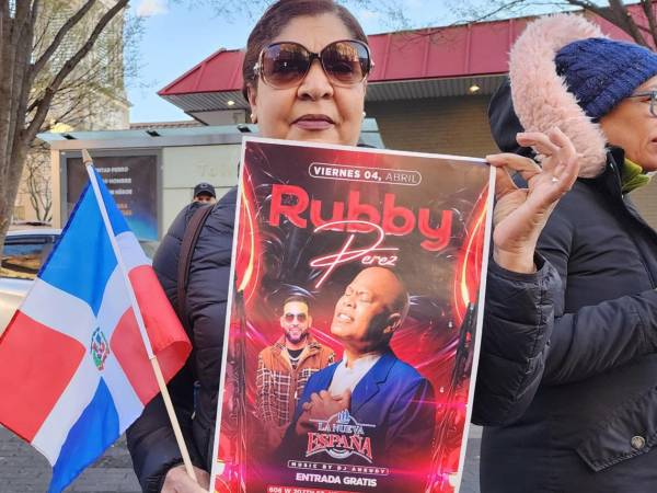 Una mujer sostiene un cartel del cantante Rubby Pérez durante una vigilia por las victimas del accidente en una discoteca de Santo Domingo este martes, en Nueva York (Estados Unidos).