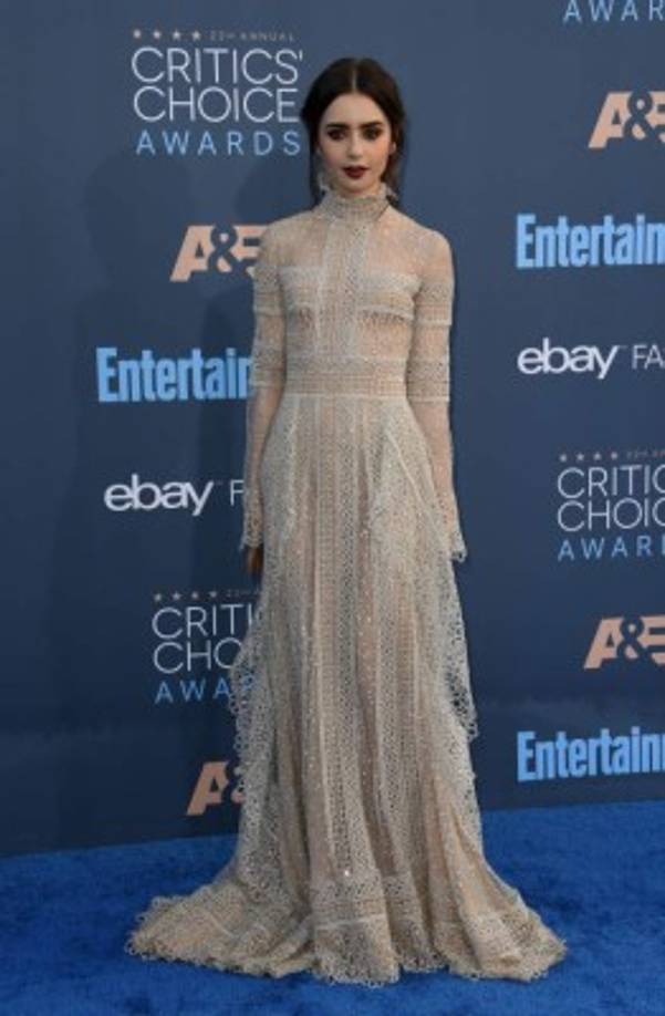 Lili Collins, con un vestido cerrado al cuello de Elie Saab, joyas Chanel y zapatos Giuseppe Zanotti.