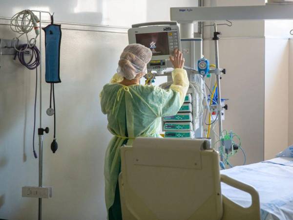 Fotografía a un personal de la salud utilizando equipo médico en una sala de hospital.