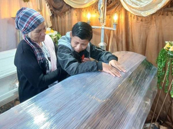 Acompañado de su abuela, el menor Kenneth Alejandro Vásquez, entre lágrimas, se despide este lunes de su madre y hermanito, quienes fallecieron en el accidente de tránsito ocurrido el domingo en Potrerillos, Cortés.