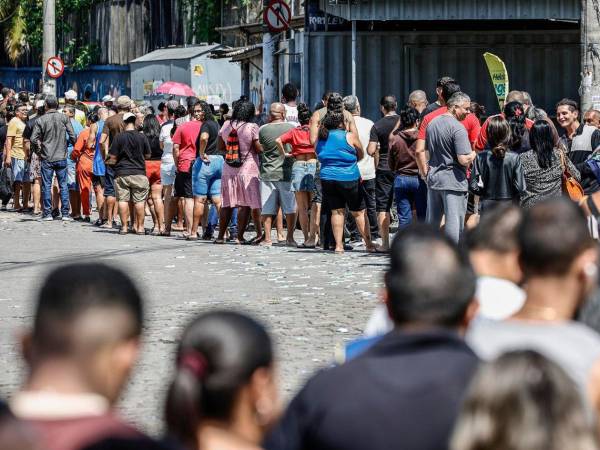 Personas hacen fila en un puesto de votación este domingo, en el barrio de Bonsucesso cerca al complejo de favelas de Maré, en Río de Janeiro (Brasil).