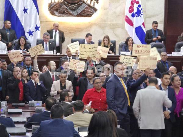 Silbidos y gritos de protesta realizan los diputados del partido Libertad y Refundación (Libre) durante la lectura del informe de la comisión de juicio político en el Congreso Nacional.