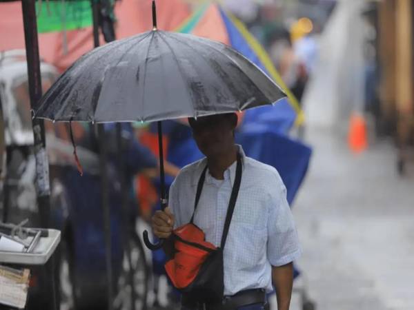 Imagen referencial de un hombre con una sombrilla en el centro de San Pedro Sula.