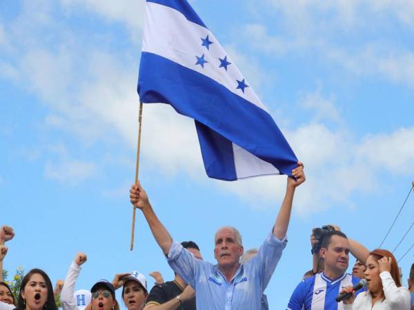 El candidato presidencial Nasry Asfura sostiene una bandera de Honduras durante la denominada 'Marcha por la defensa de la democracia' este sábado, en Tegucigalpa (Honduras). EFE/ Gustavo Amador