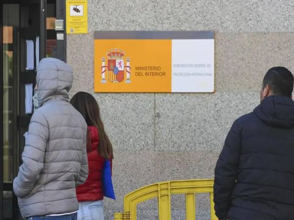 Una oficina para solicitantes de asilo en Madrid ante la que esperan inmigrantes latinoamericanos. EFE/Archivo