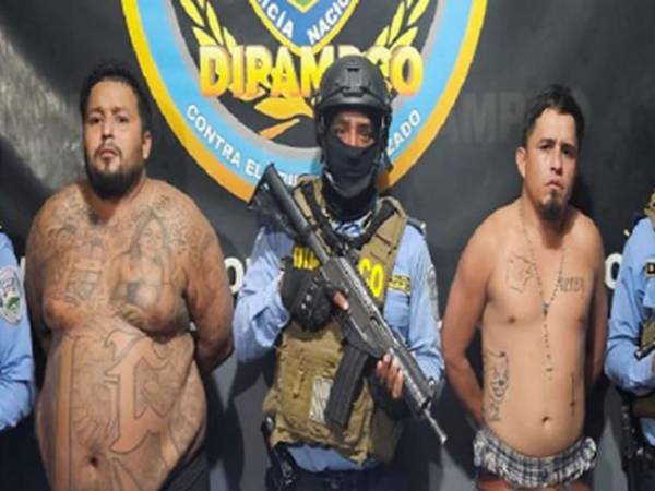 Los dos hombres bajo custodia policial de la Dipampco posan junto a agentes especiales del equipo táctico tras su detención.