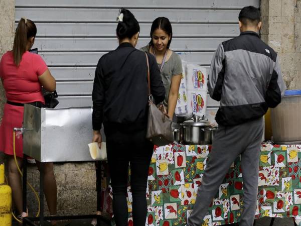 Personas compran alimentos en un puesto de comidas este martes, en Tegucigalpa (Honduras). EFE