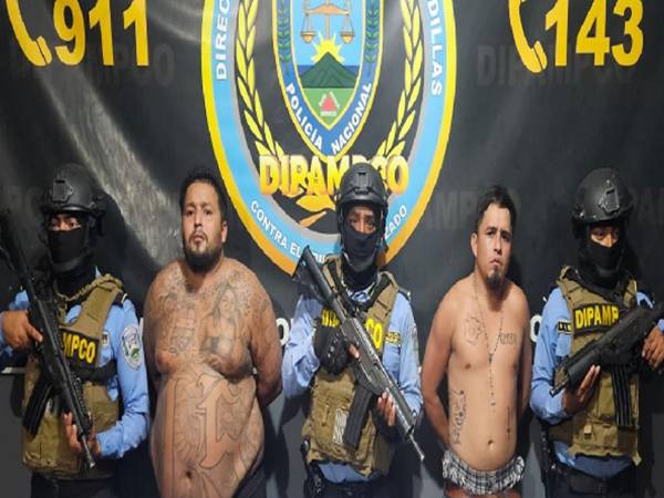 Los dos hombres bajo custodia policial de la Dipampco posan junto a agentes especiales del equipo táctico tras su detención.