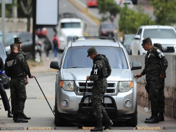Integrantes de la Policía Militar de Honduras registran un vehículo en el ingreso del Instituto Nacional de Formación Profesional (Infop), lugar donde se encuentra el Centro Logístico Electoral en Tegucigalpa. EFE Gustavo Amador