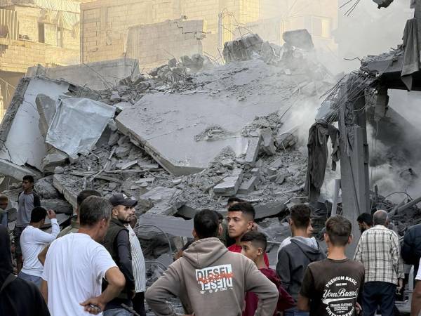 Varios hombres observan los escombros tras uno de los ataques lanzados este domingo por Israel en Gaza. EFE/Str