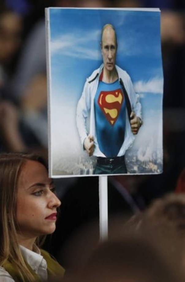 RUSIA. Cita anual con periodistas. Una periodista rusa con un póster de Vladimir Putin representado como Superman.