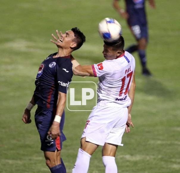 Roberto Moreira salta por el balón con Jonathan Paz.