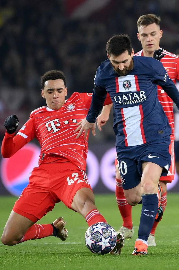 Jamal Musiala se barre para robarle el balón a Lionel Messi.