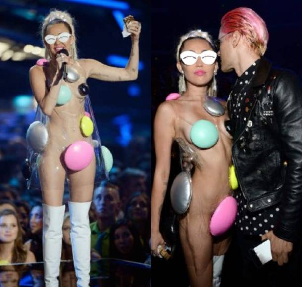 Con un vestido de plástico transparente decorado con puntos de colores en las zonas 'clave', botas altas de charol blancas y una maxi coleta de rastas Miley sorprendió al público una vez más.