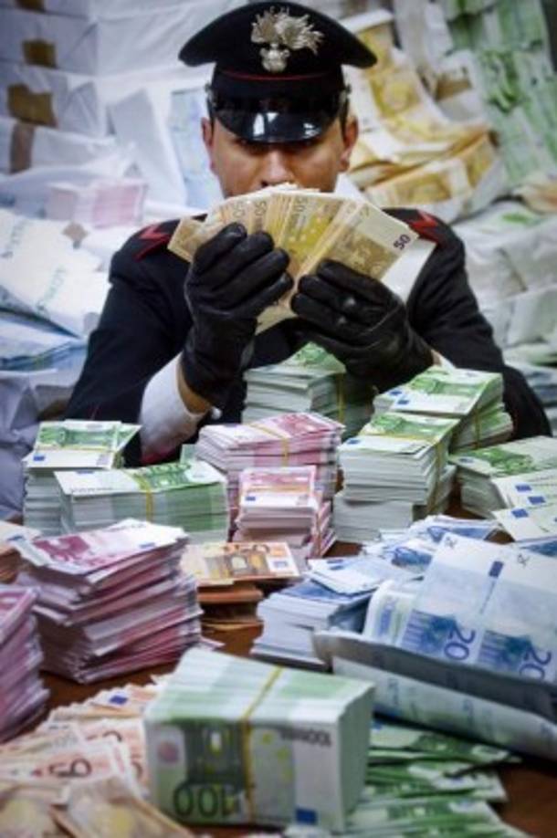 Un policía cuenta euros falsos tras detener a una banda de falsificadores cerca de Nápoles, en Italia.