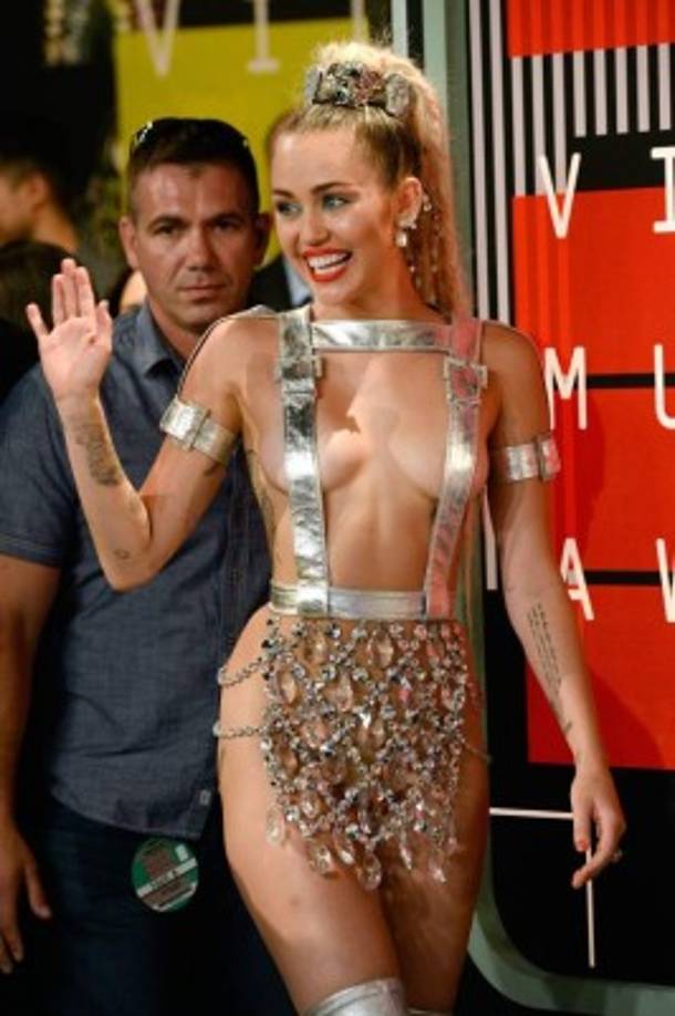 La intérprete de 'Wrecking Ball' llevaba puestas unas botas que terminan arriba de sus rodillas y para darle un toque más femenino y atrevido, una pequeña bolsa de mano.