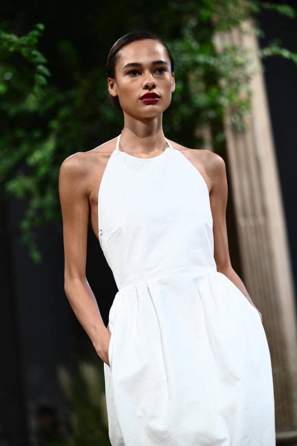 Una serie de sencillos trajes de noche monocromáticos cerraron el desfile, el look final comprendió una sencilla camisa blanca de dril de algodón, una flotante falda larga de gasa negra y un delantal estilo jardinero, personificando la yuxtaposición de elegancia y utilidad que atravesaba todo el desfile.