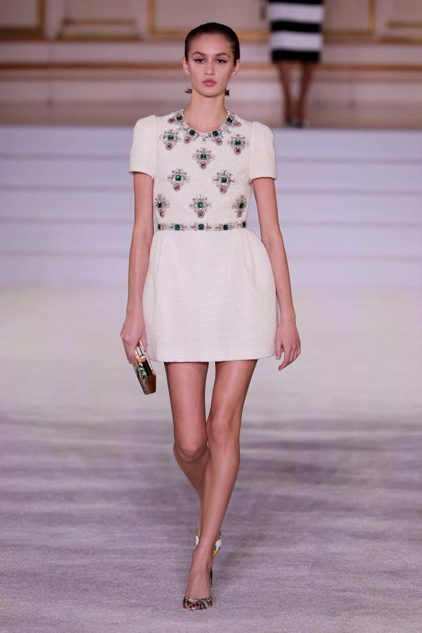 Entre sus propuestas, para el día se destacaron varios minivestidos, como uno de tweed blanco en manga corta recubierto de joyas plateadas y verdes en el pecho, el cuello y la cintura, y otro de color rosa fucsia en manga larga y líneas de pedrería bordadas en el mismo color.