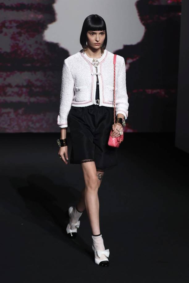 La sobriedad del blanco y el negro, y la dulzura de los tonos amarillos y rosados recibieron una dosis extra de sofisticación con las lentejuelas y plumas que abundaron en esta colección, como un vestido blanco con lentejuelas metalizadas y un filo de volantes de pluma en el bajo.