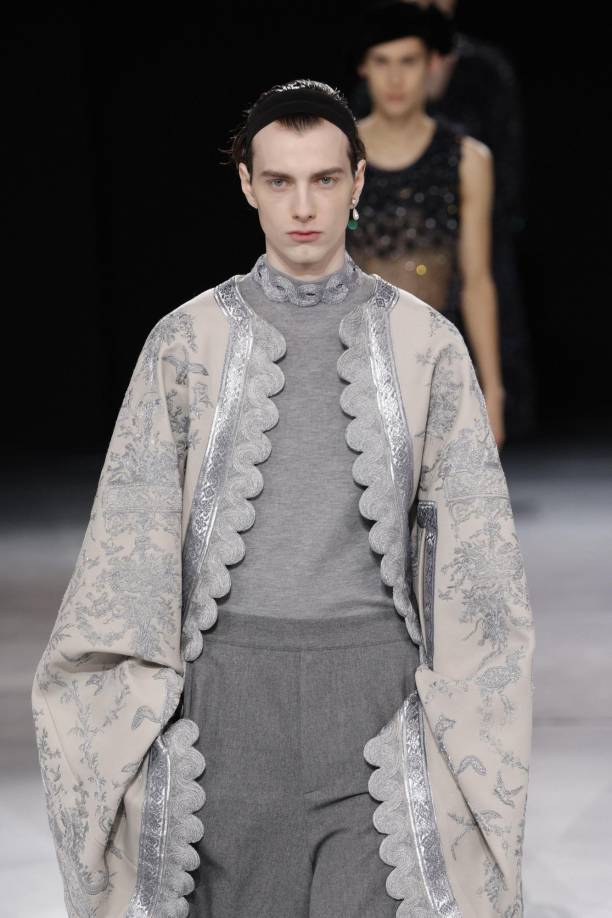 Destacó una capa de tonos grises bordada con hilo de plata que necesitó más de 2.000 horas de trabajo, a cargo del taller especialista Vermont.Jones deconstruye los trajes de línea inglesa, con los pantalones cortados al borde de la rodilla, y cerrados con cremallera en lugar de botones. El cuello, en forma de V.