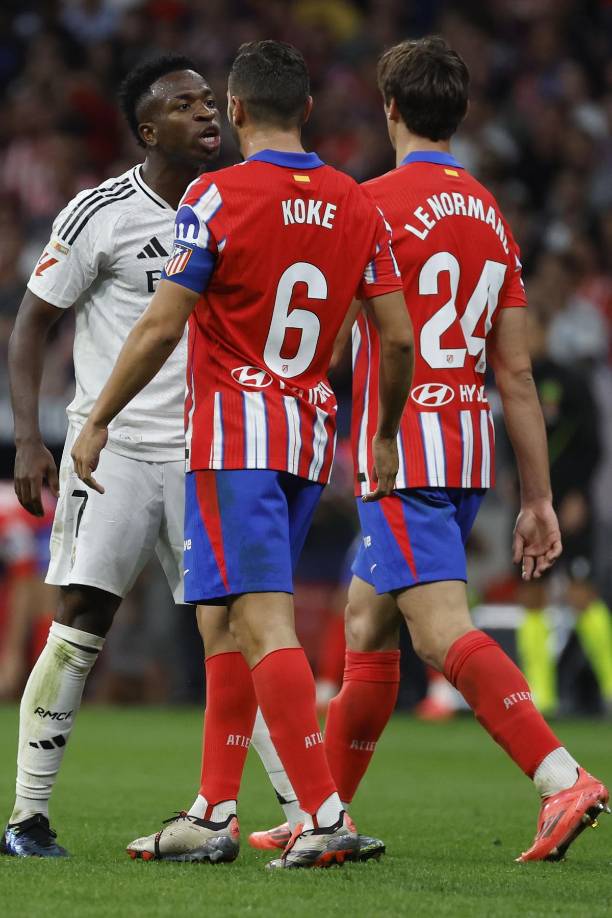 Vinicius Junior se encara con Koke Resurrección y Robin Le Normand en un momento del derbi.