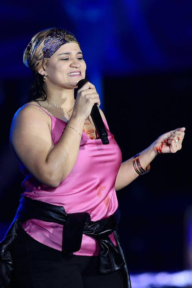 Pero estar junto a los reyes de la bachata para ella tuvo un precio, ya que se lastimó cuando intentaba subir y hasta sangró, de inmediato se llenó el pecho, la blusa y las manos de sangre, pero esto no impidió que disfrutara su momento. 