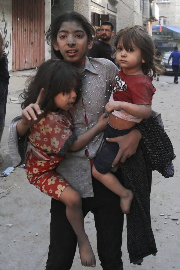 Entre las idas y venidas de ambulancias, se amontonan vecinos para preguntar sobre sus allegados. Los heridos que vienen y van y también hay niños sentados en el suelo, paralizados, en silencio.