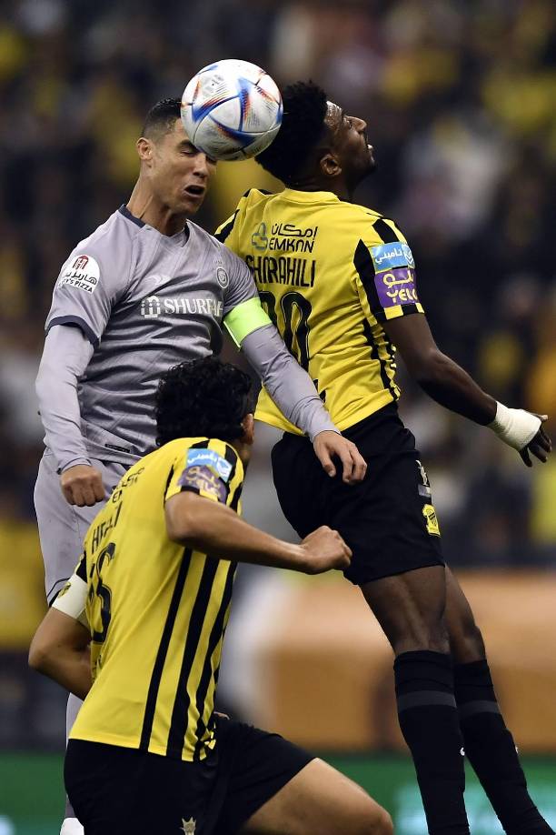 Cristiano Ronaldo saltando por un balón con la defensa del Al-Ittihad.